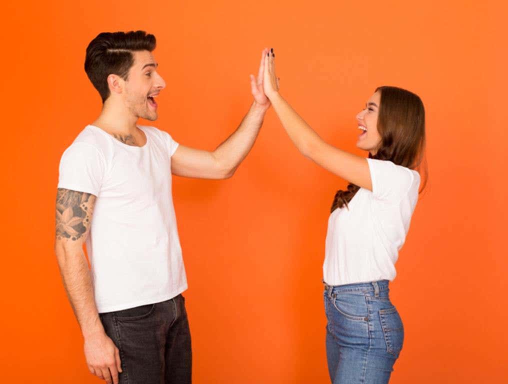 Happy guy and girl giving high five, greeting each other (Starry Etiquette: And the Most Polite Zodiac Sign Is...)