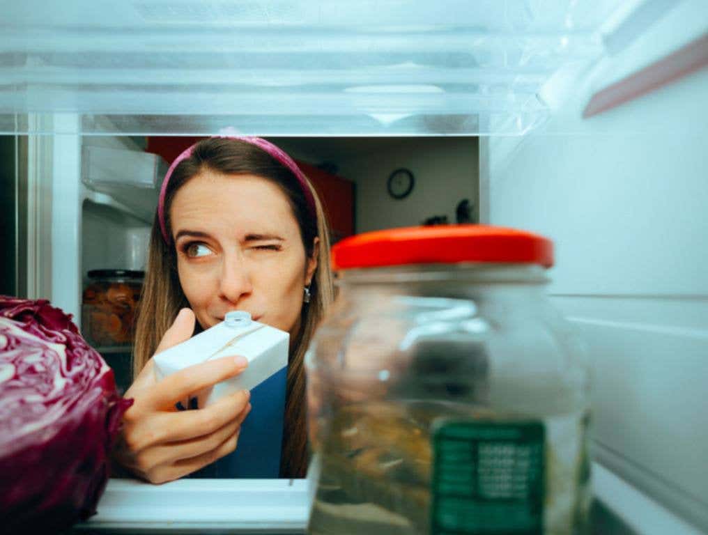 Cautious millennial girl checking the smell of her diary product