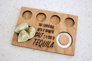 wooden tequila flight board with words take everything with a grain of salt and a shot of tequila